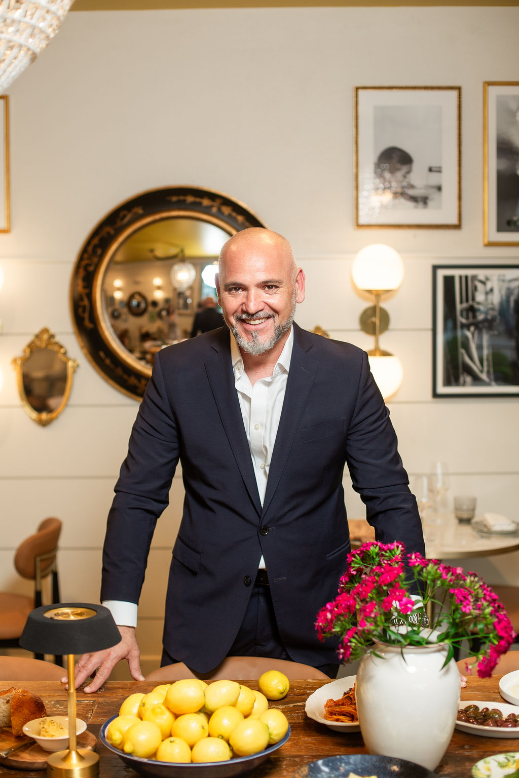 a man in a suit standing next to a table with flowers