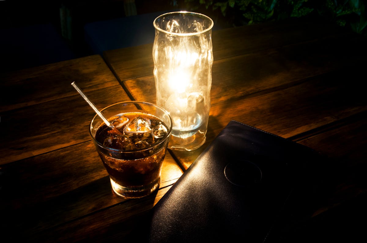 a glass of beer on a table with wine glasses