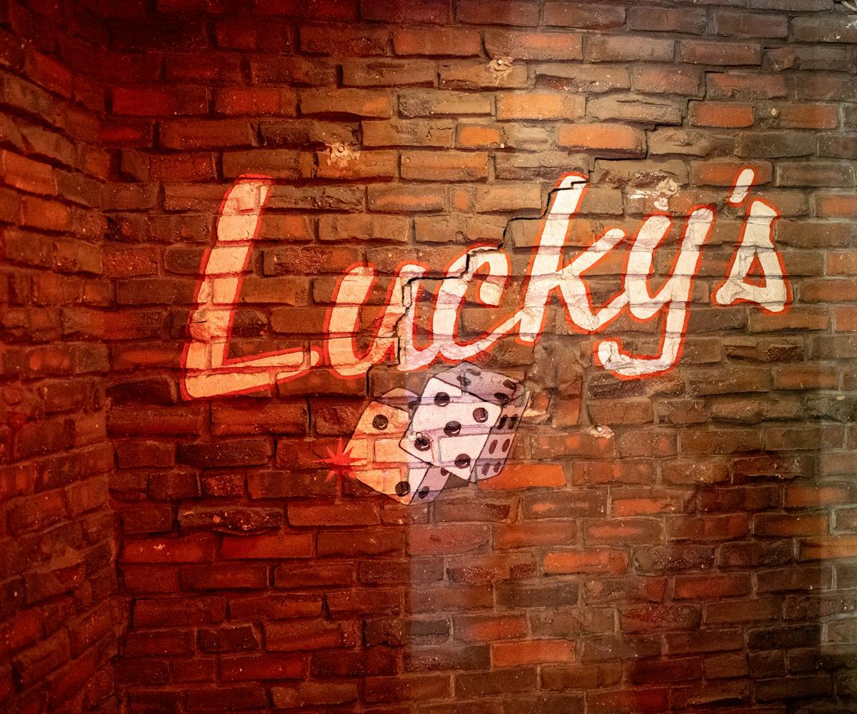 Lucky's Lounge Logo on brick wall