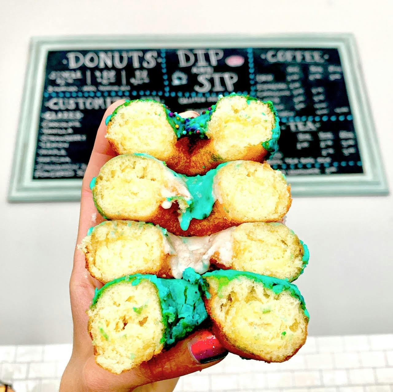 a hand holding sliced donuts