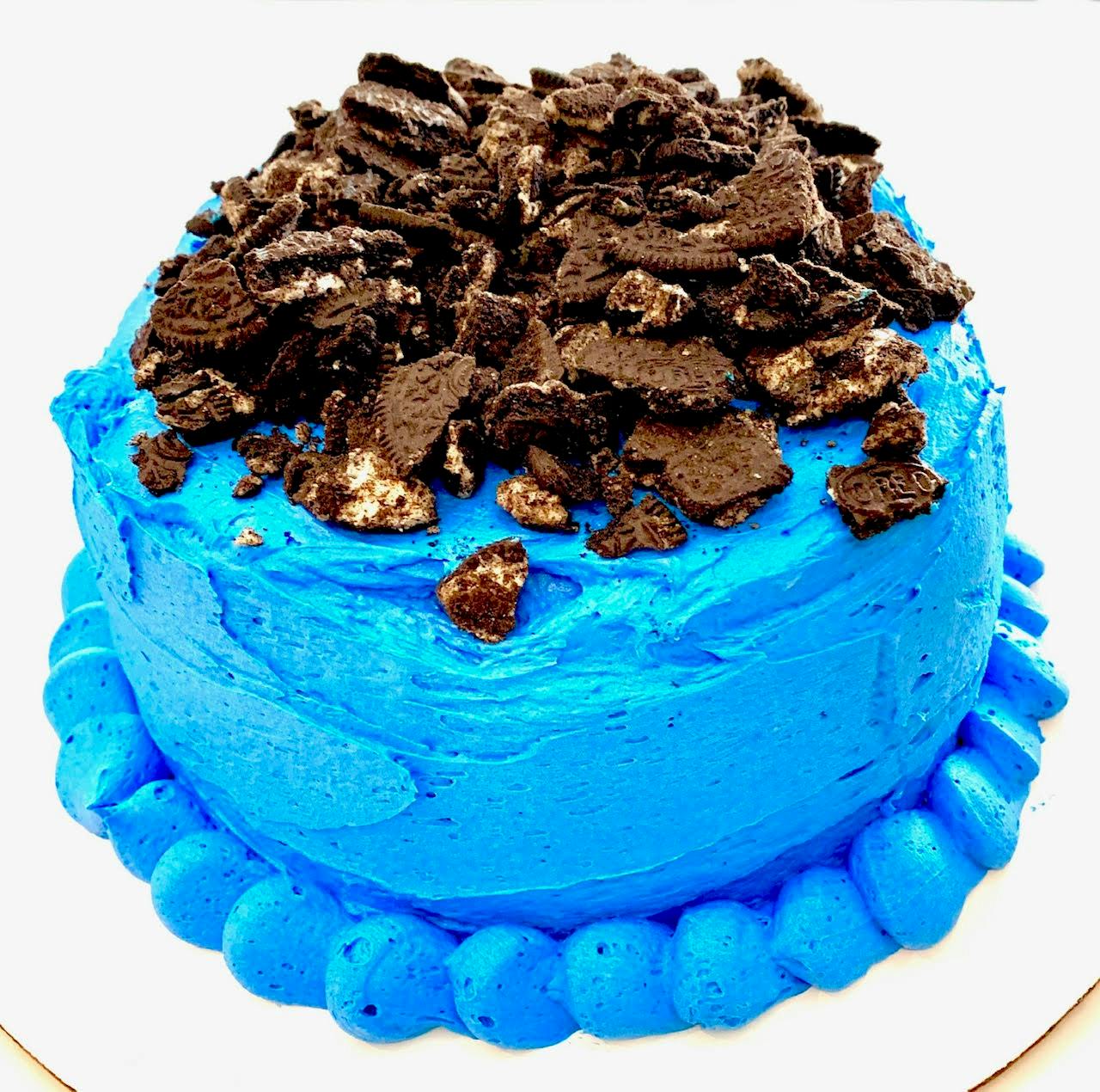 a blue cake with with chocolate pieces on top