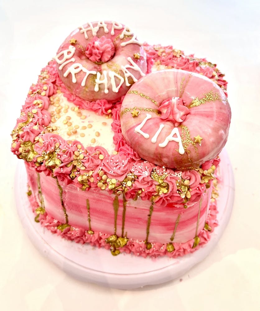 a pink cake sitting on top of a table