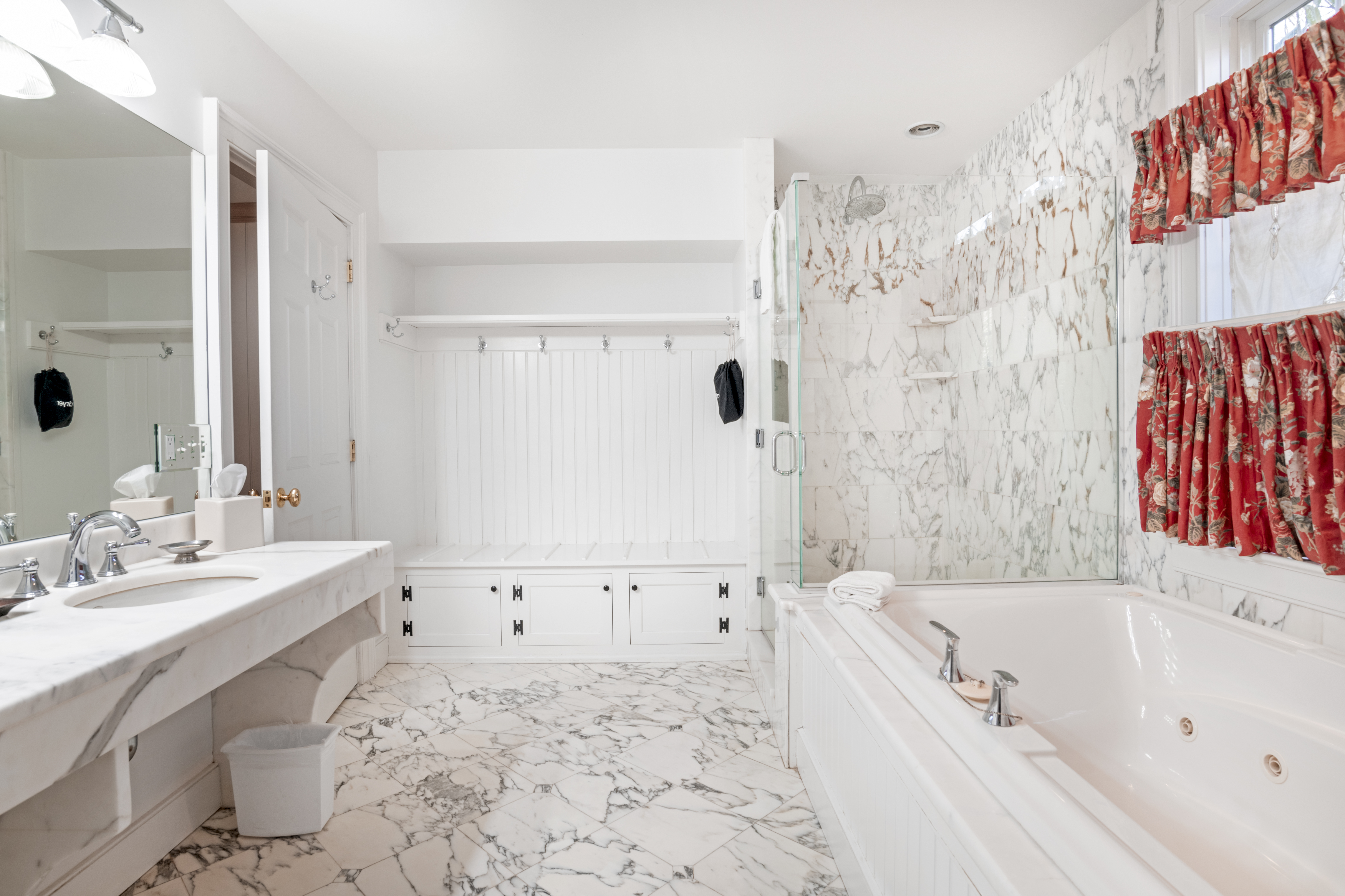 a bathroom with marble floor and tub
