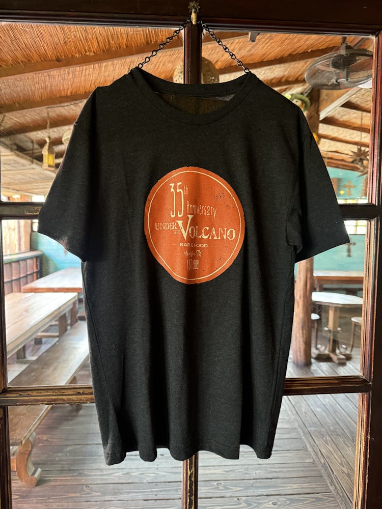 Black t-shirt with a round logo saying 35 Anniversary Under the Volcano