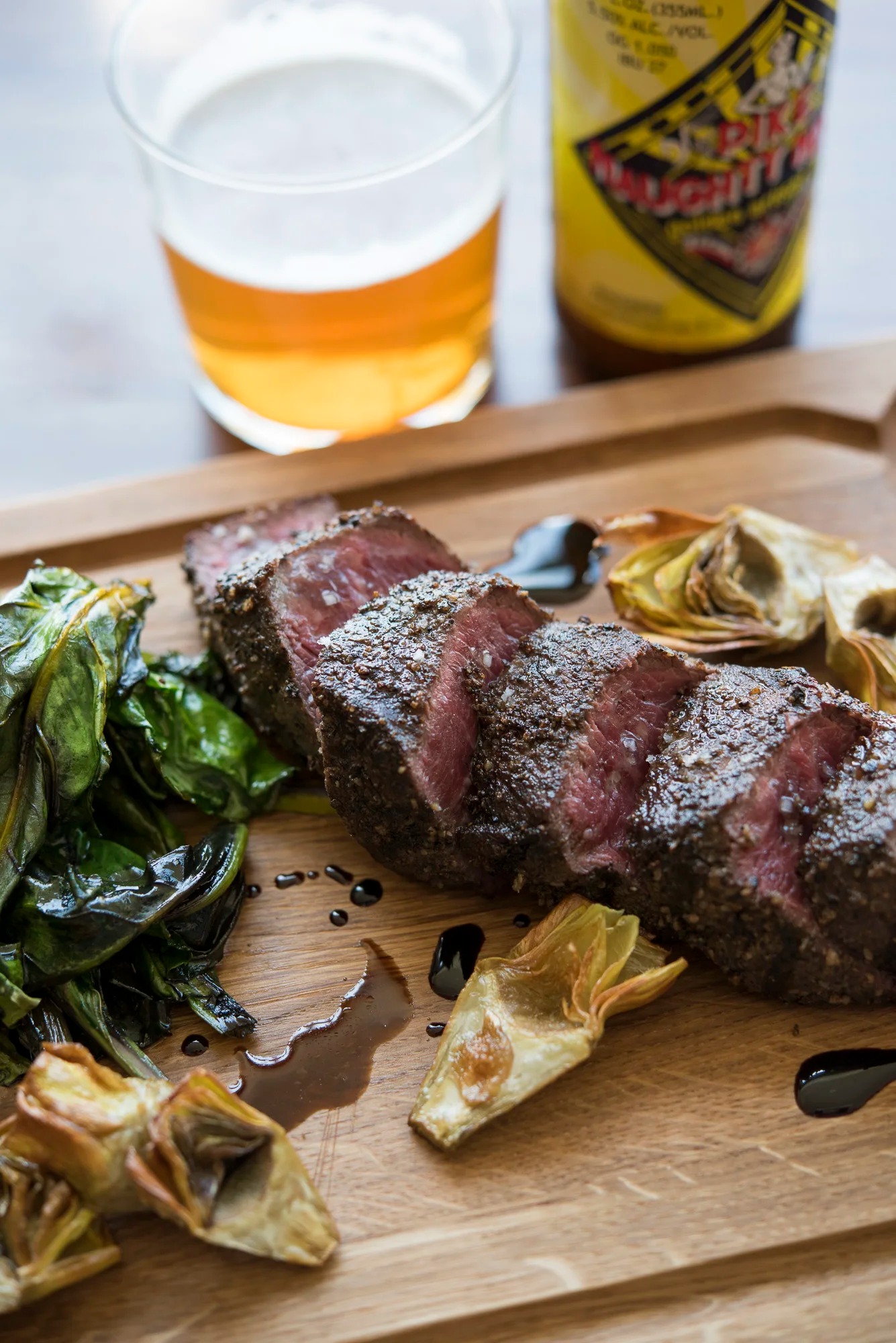 a steak and vegetables on a wooden board