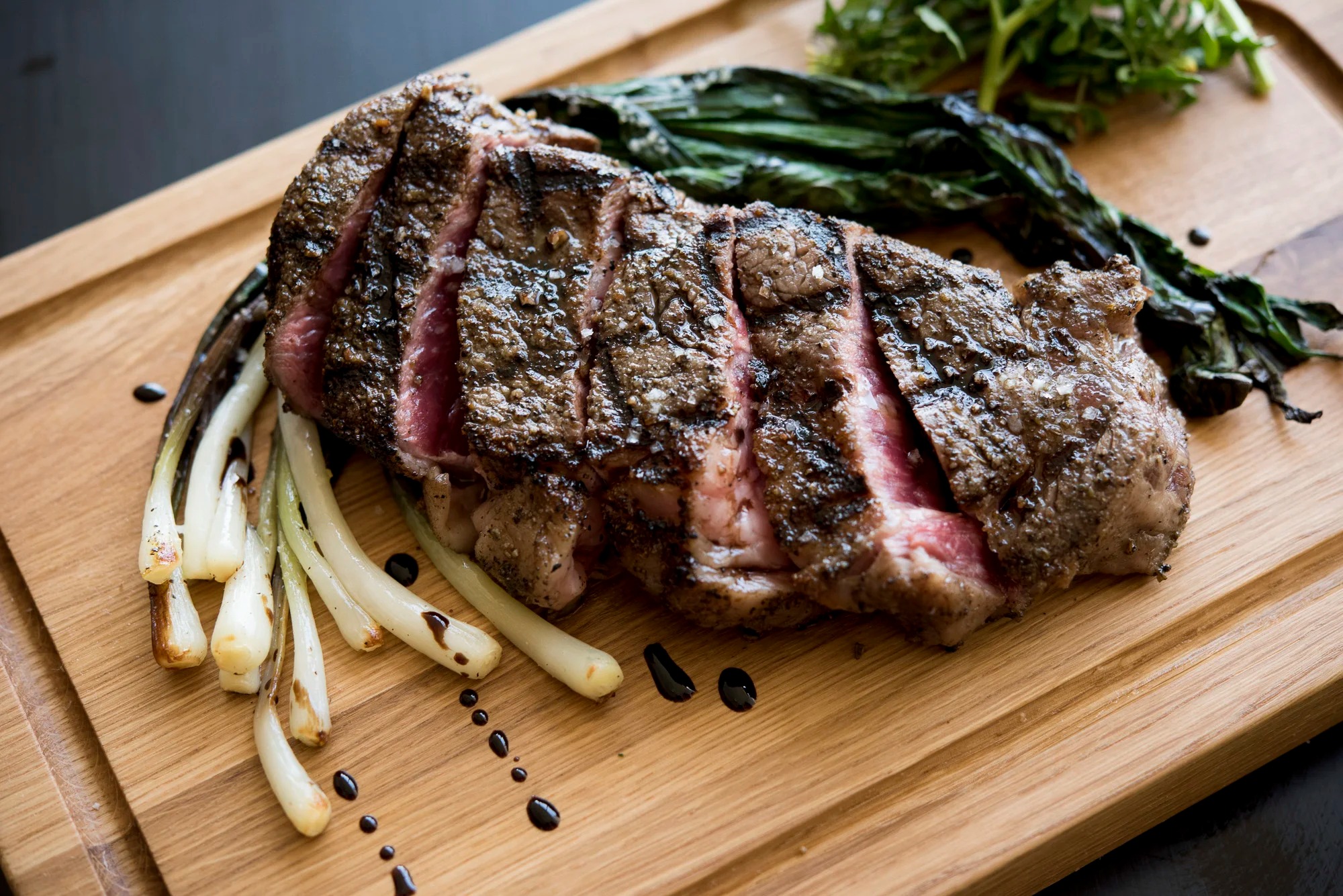 a piece of steak with vegetables on a wooden board