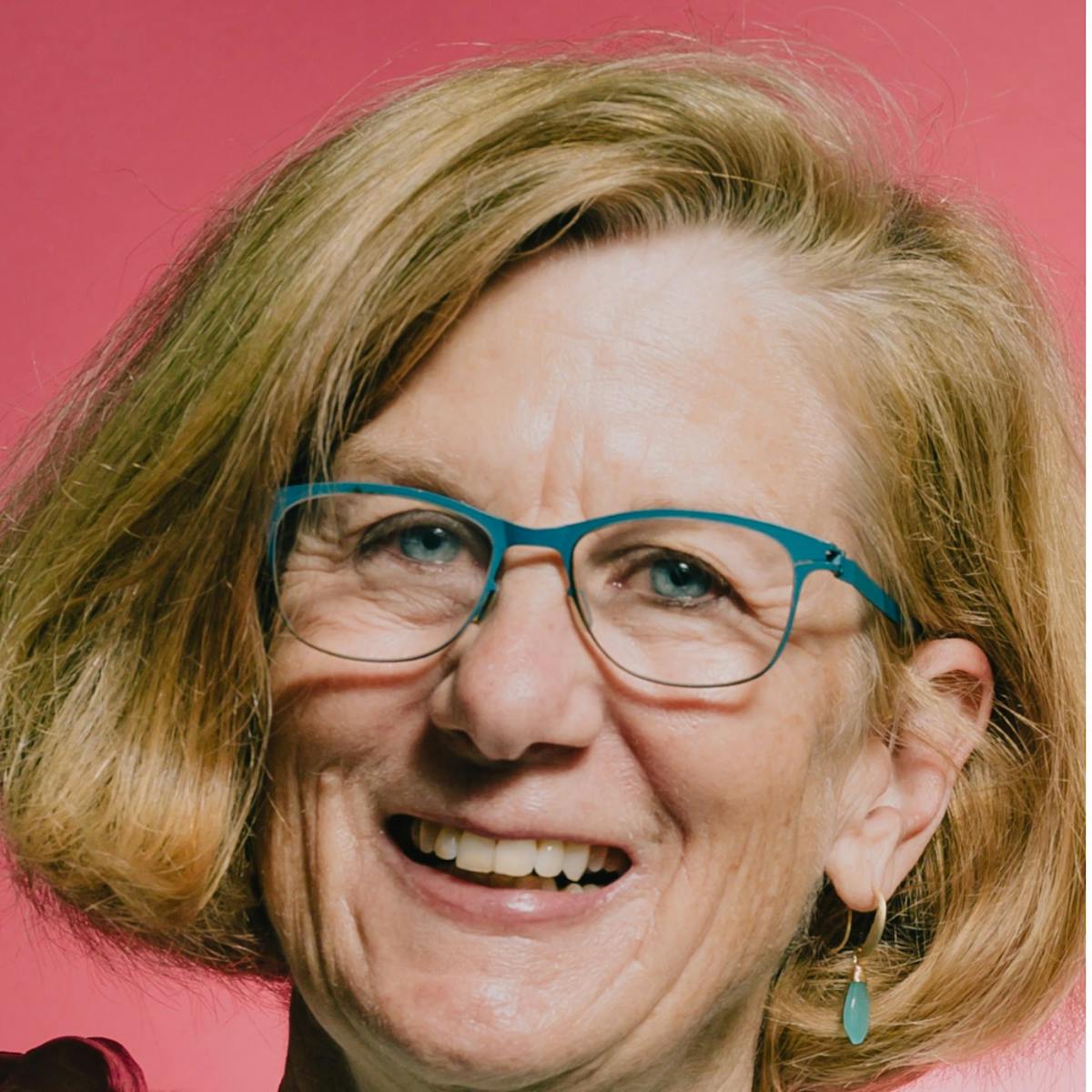 a close up of Carolyn Kenady wearing glasses and smiling at the camera
