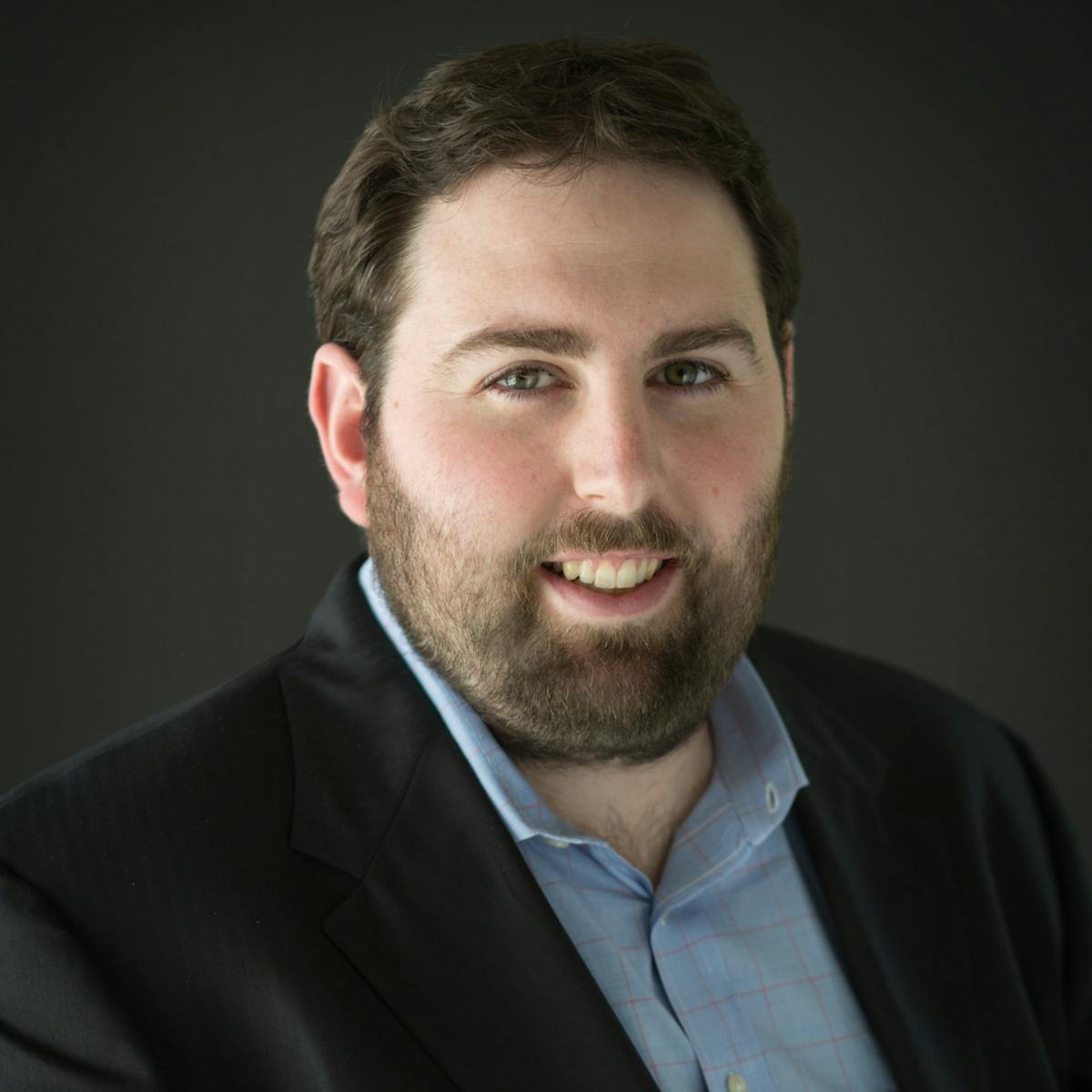 a man wearing a suit and tie looking at the camera