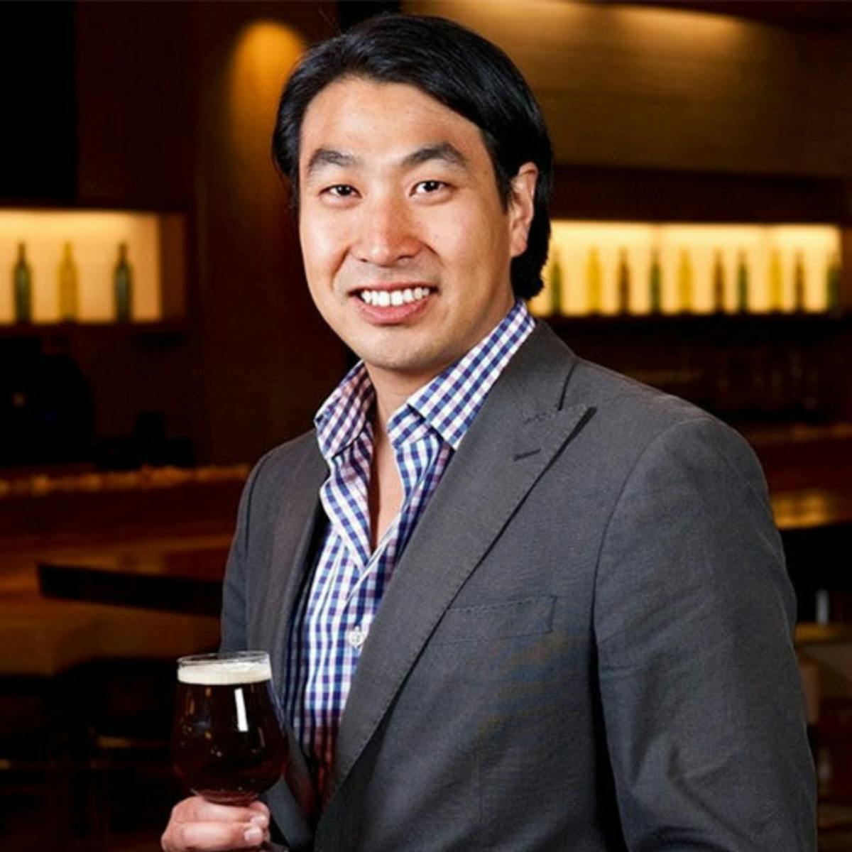 a man wearing a suit and tie smiling at the camera