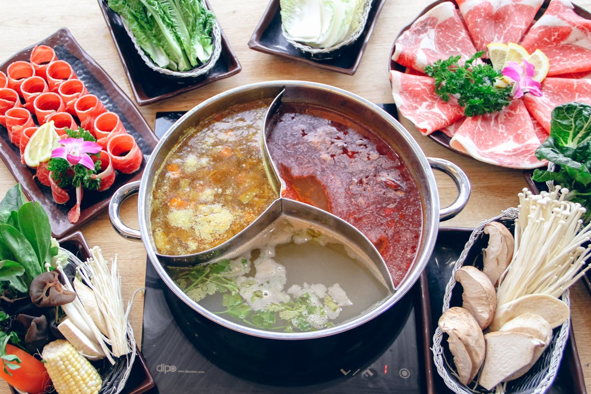 hot pot table top with soup, veggies and meats
