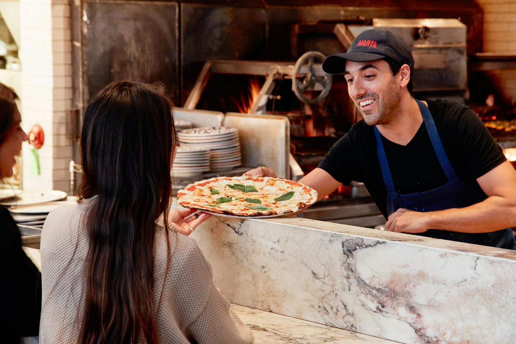 a woman sitting at a table eating pizza