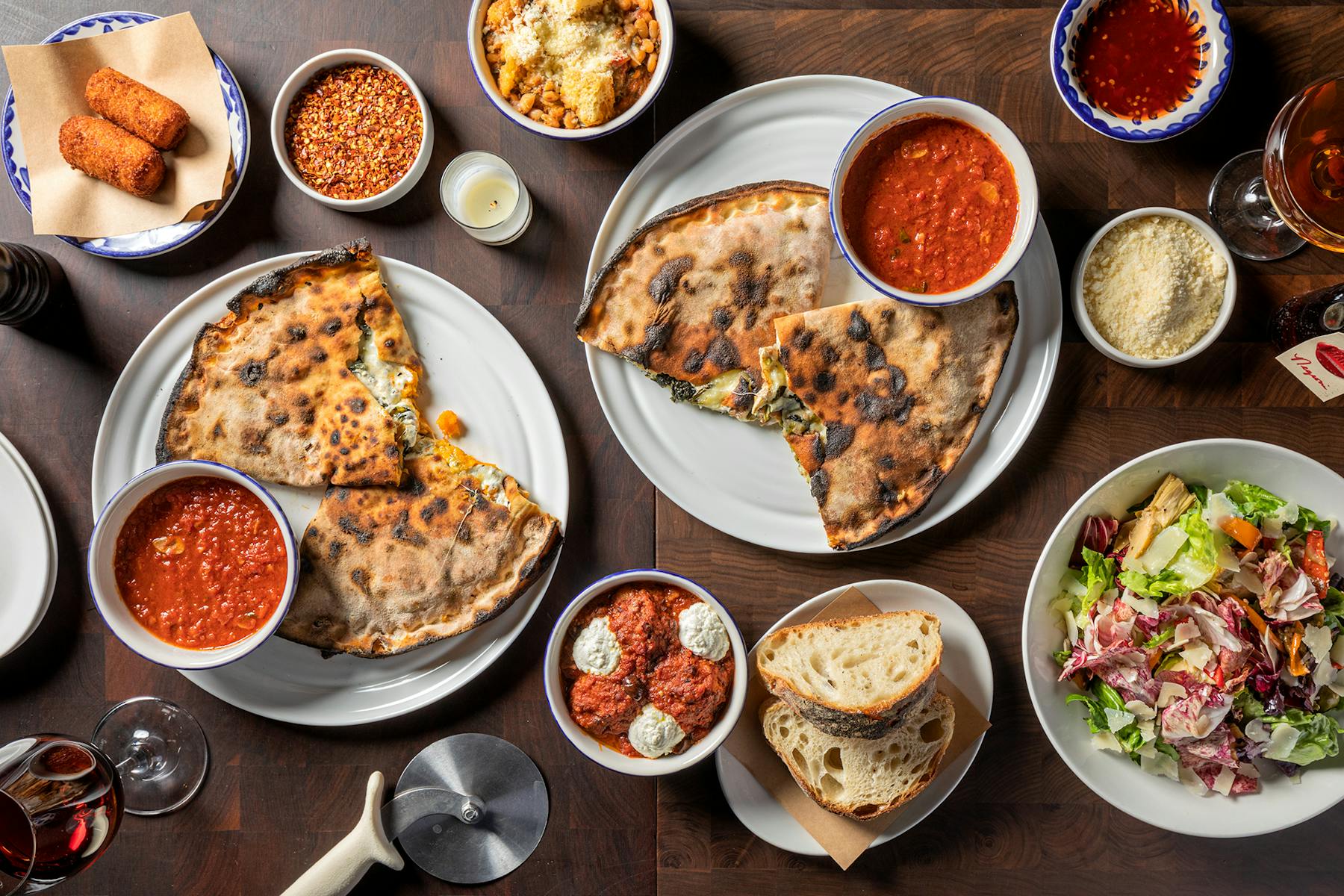 a table filled with calzones and sides from Marta