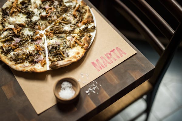 a pizza sitting on top of a wooden cutting board