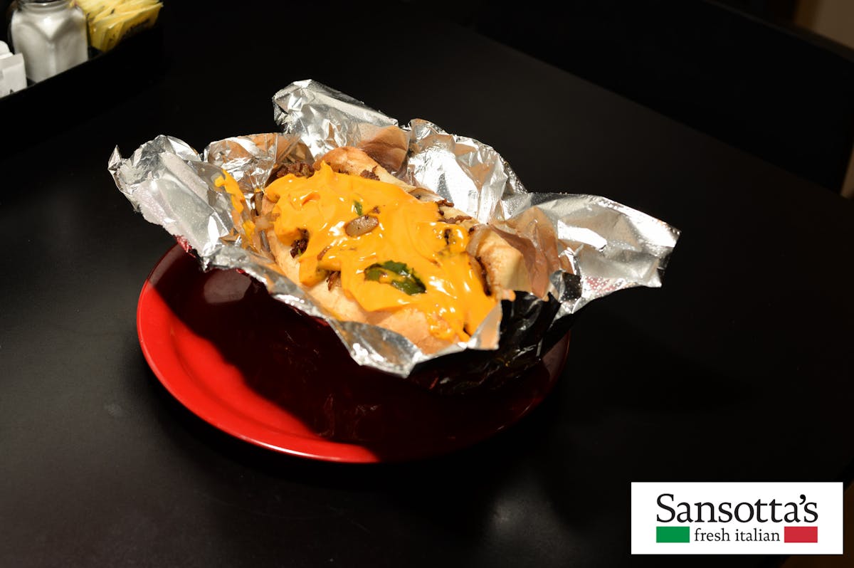 a hotdog served on aluminum foil with cheese 