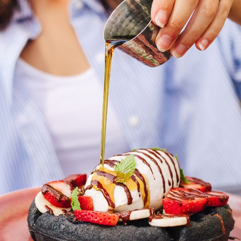 a close up of a person holding a piece of cake on a plate