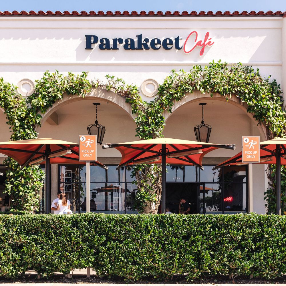 Exterior view of Parakeet Cafe in Newport Beach with outdoor seating and Mediterranean-style arches — a cozy spot for breakfast in Newport Beach.