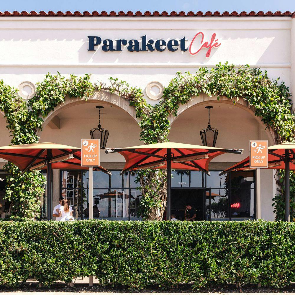 Exterior view of Parakeet Cafe in Newport Beach with outdoor seating and Mediterranean-style arches — a cozy spot for breakfast in Newport Beach.