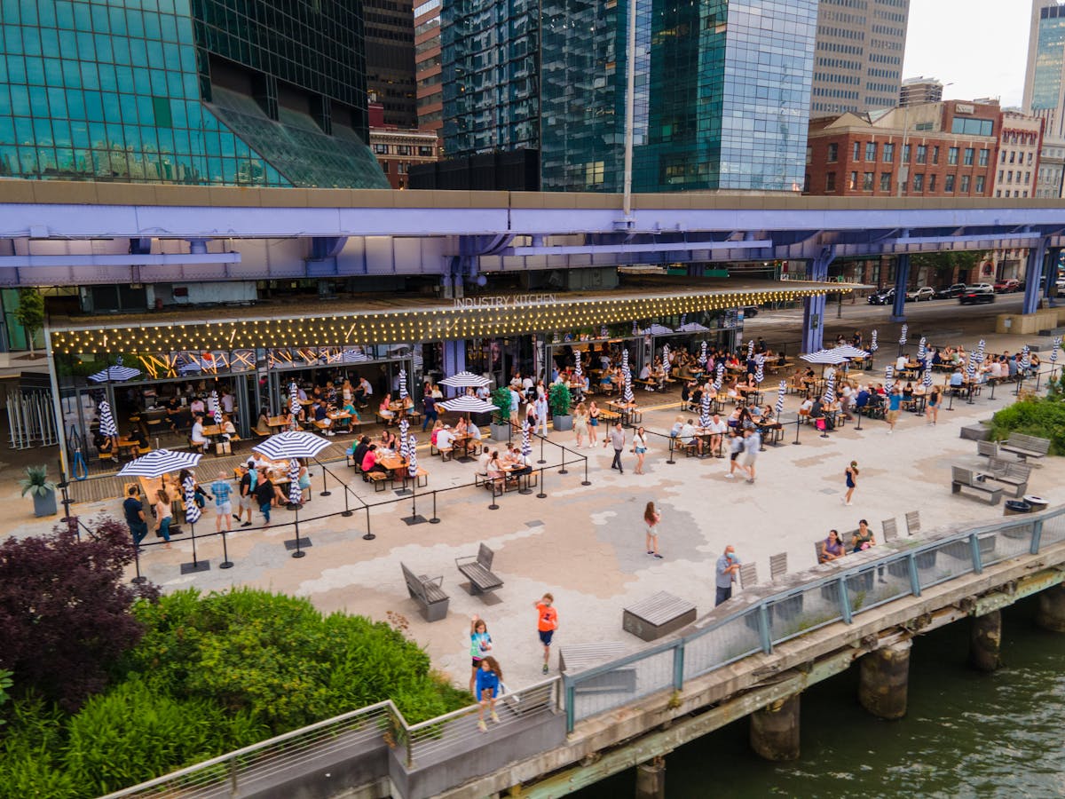 a group of people on a bridge over a river in a city