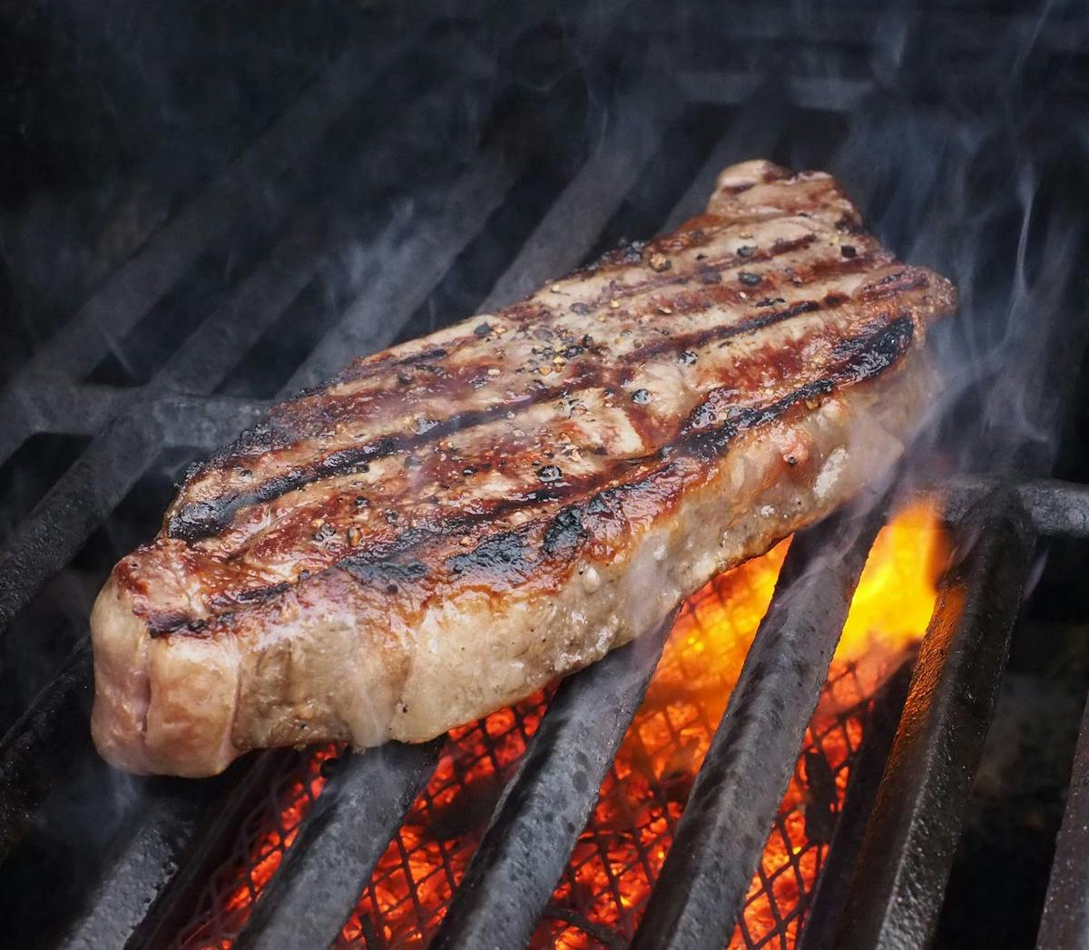 a piece of meat being cooked on a grill