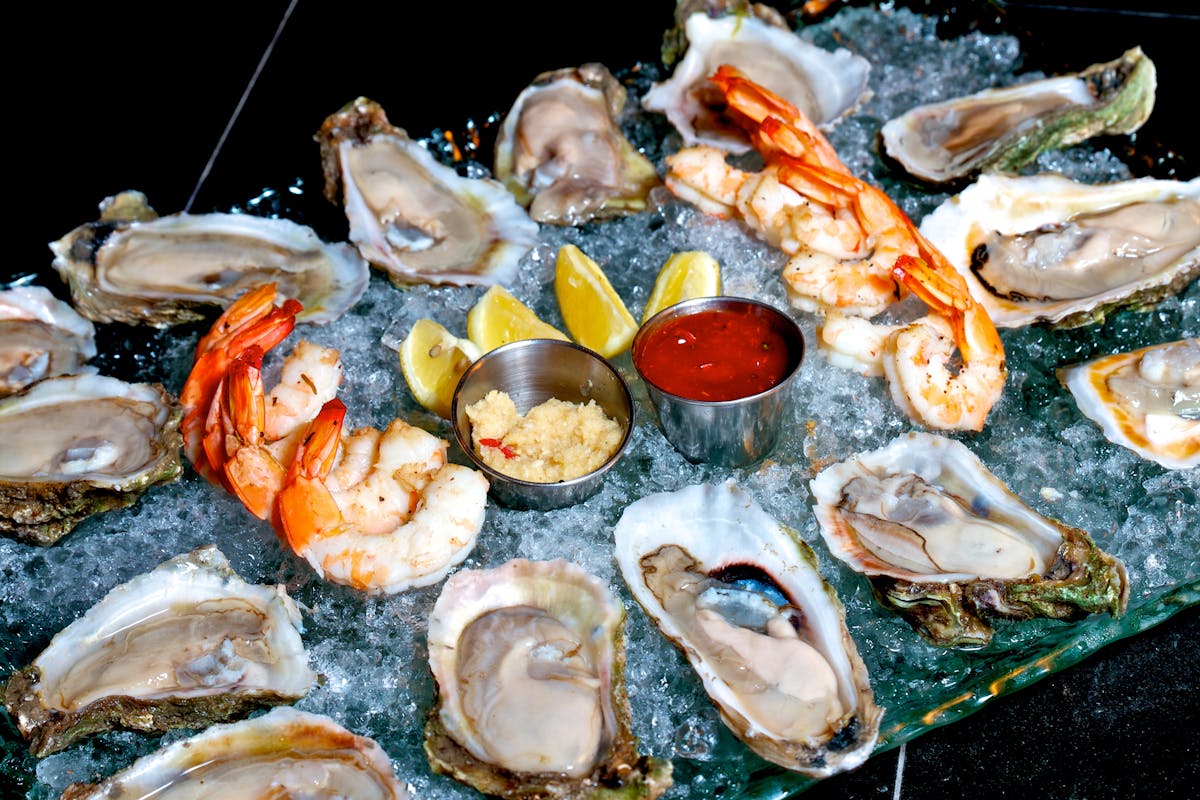 multiple opened oysters sitting on ice