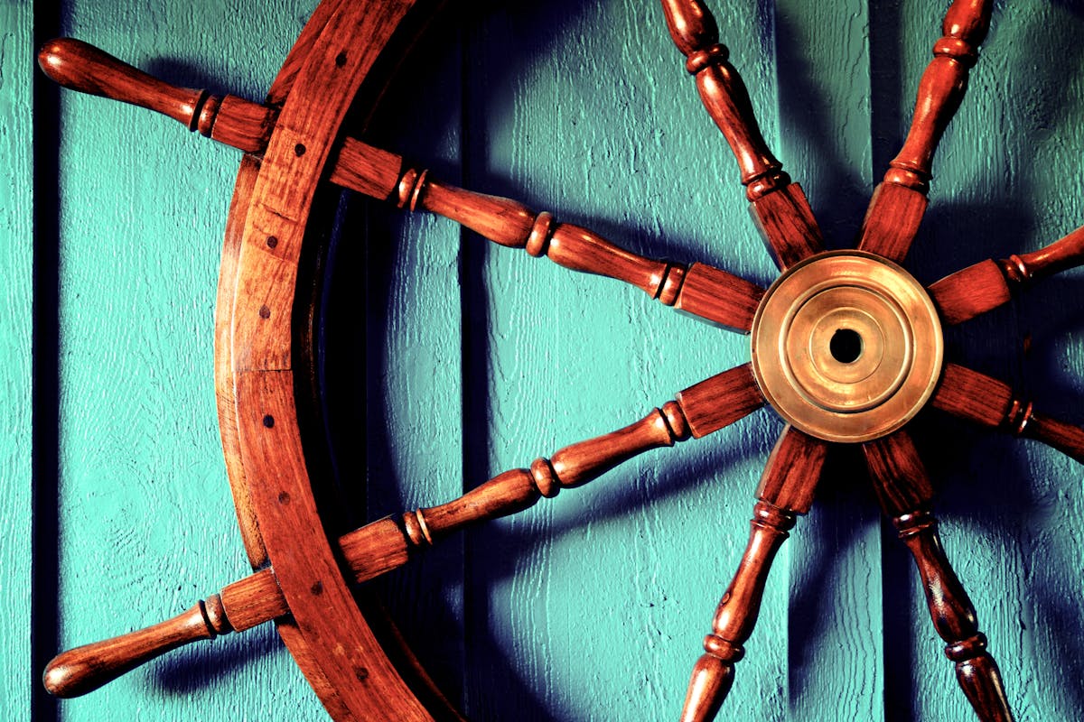 a closeup of a boat's wooden steering wheel