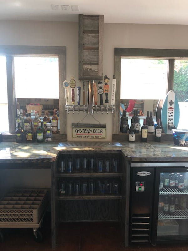 a bar topped with wine bottles and beers