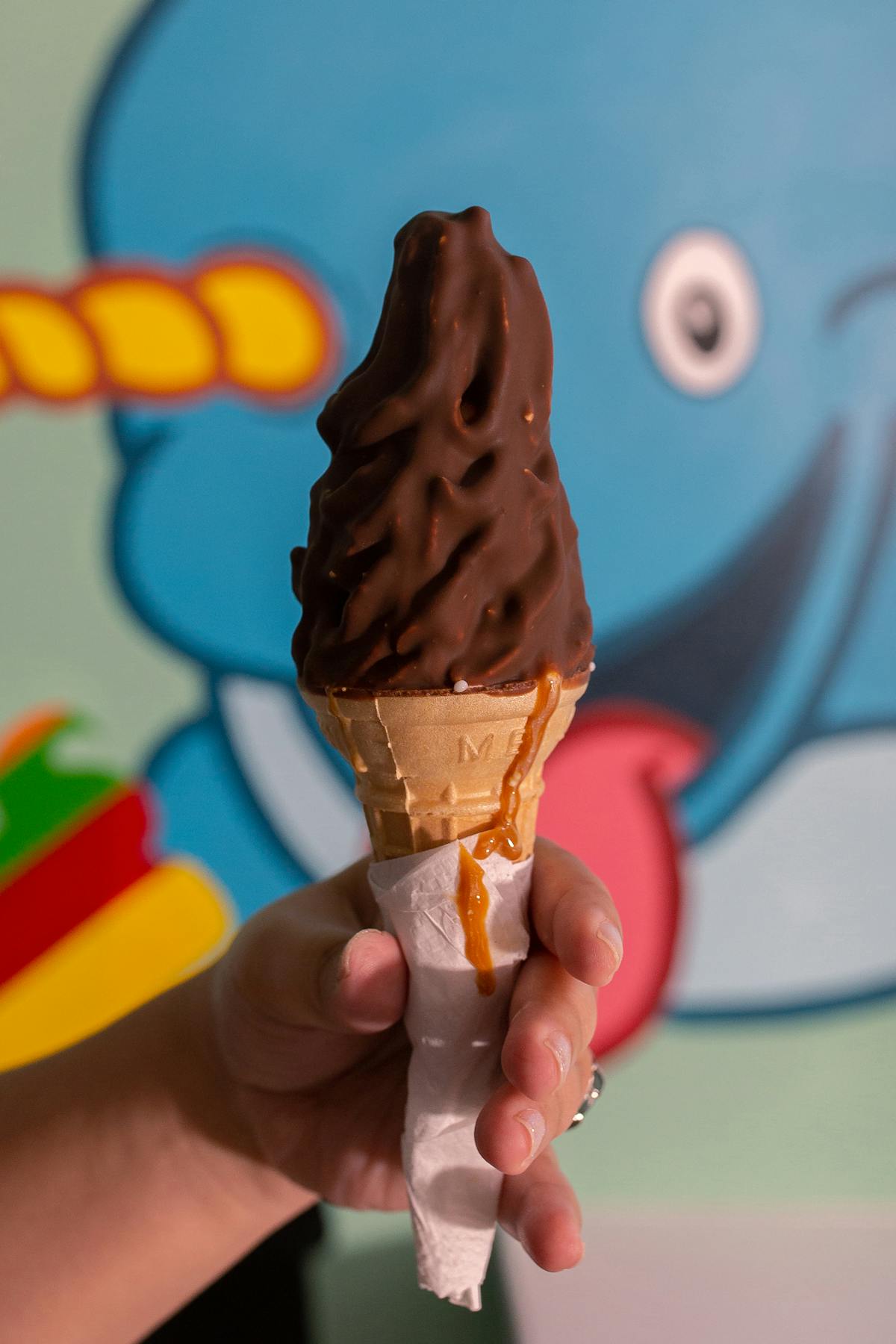 a hand holding a chocolate ice cream