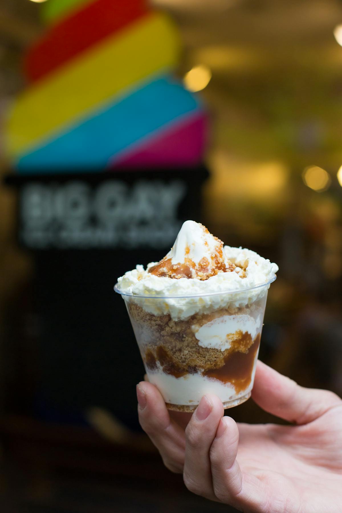 a hand holding a sundae