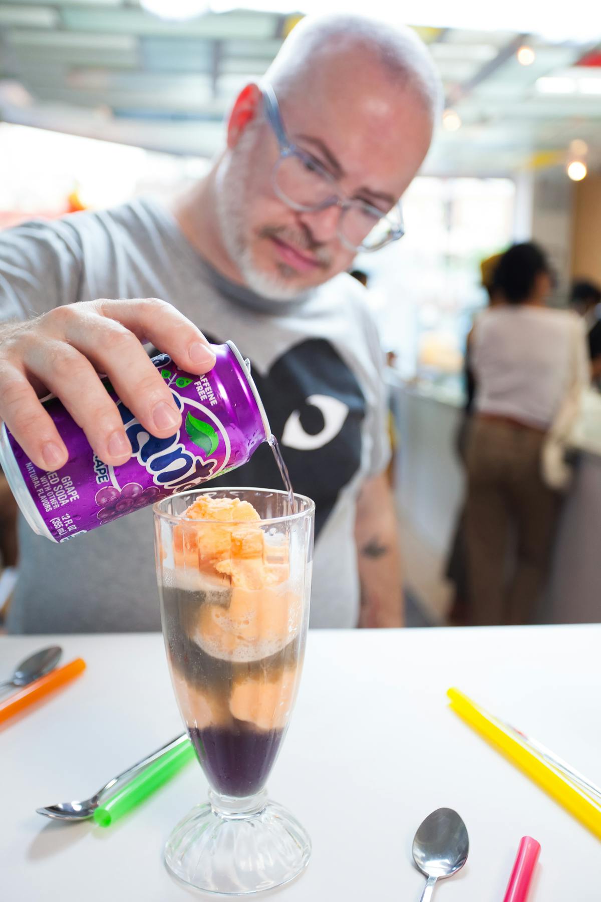 a man pouring soda on an ice cream vase