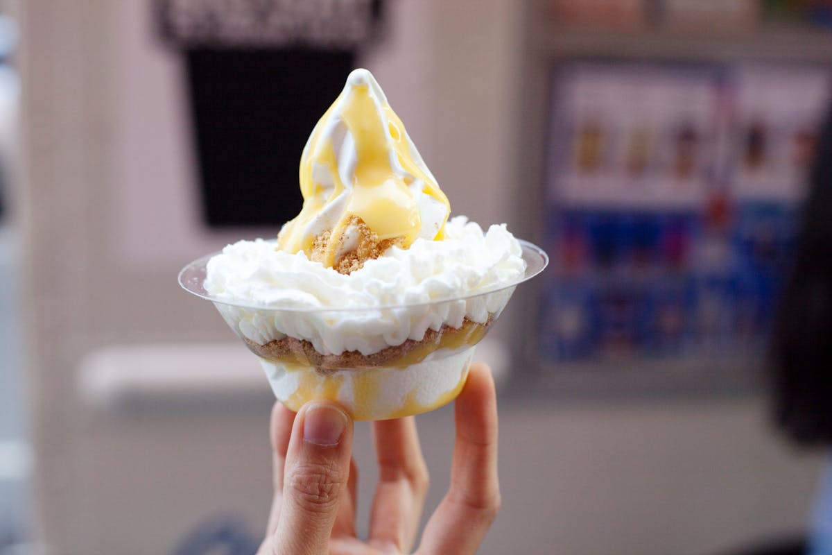 a hand holding a sundae