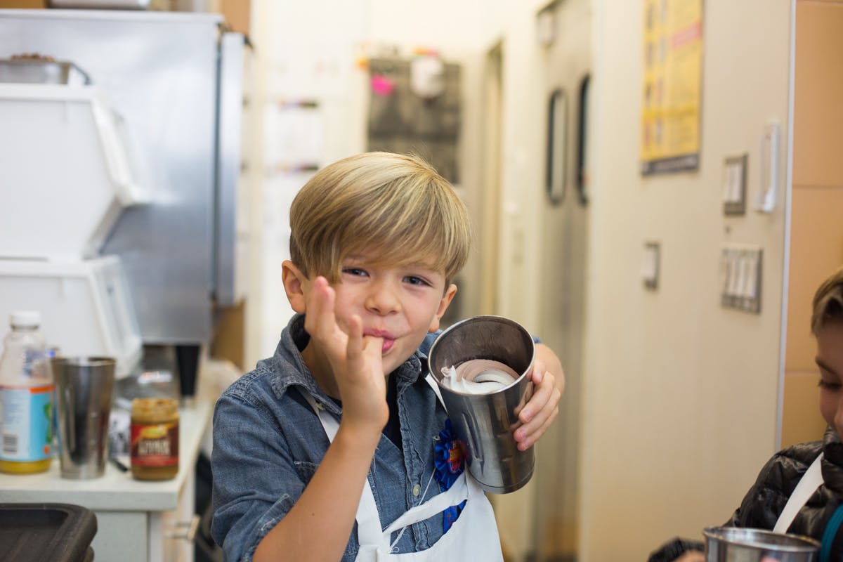 a young boy is preparing food in a kitchen
