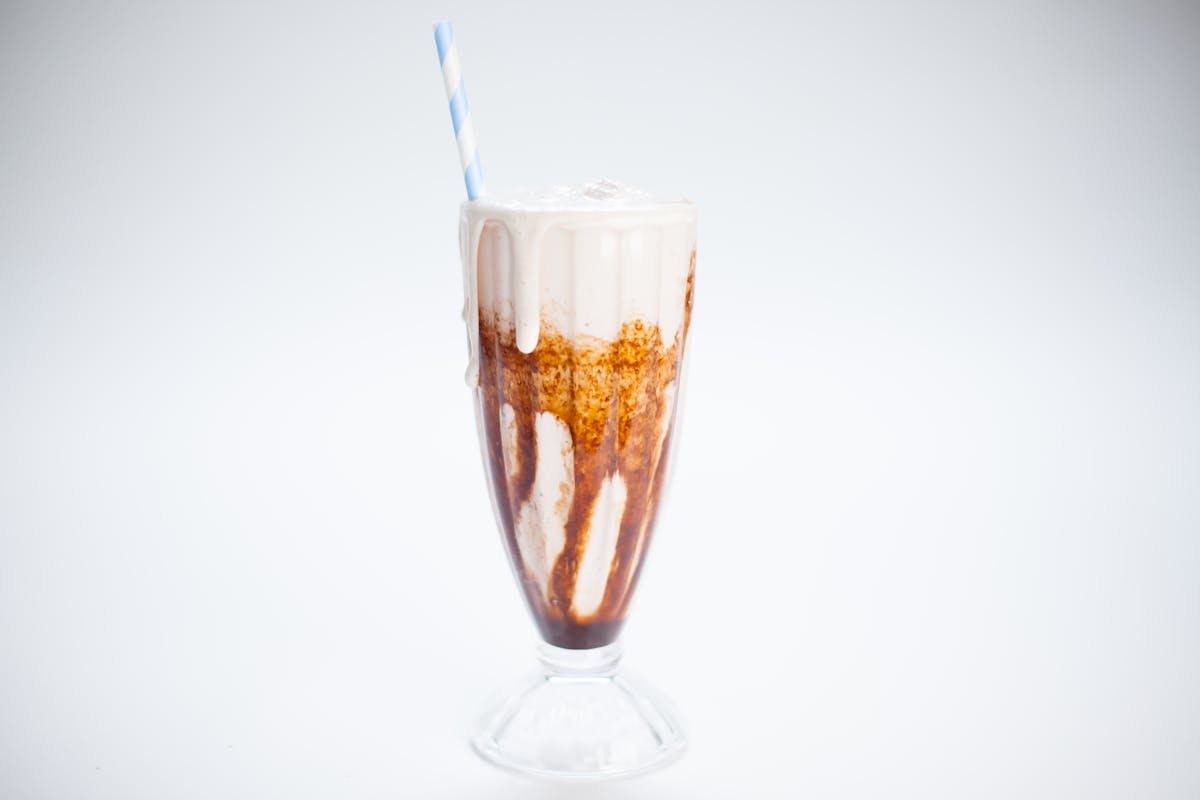 a vanilla milkshake with a straw
