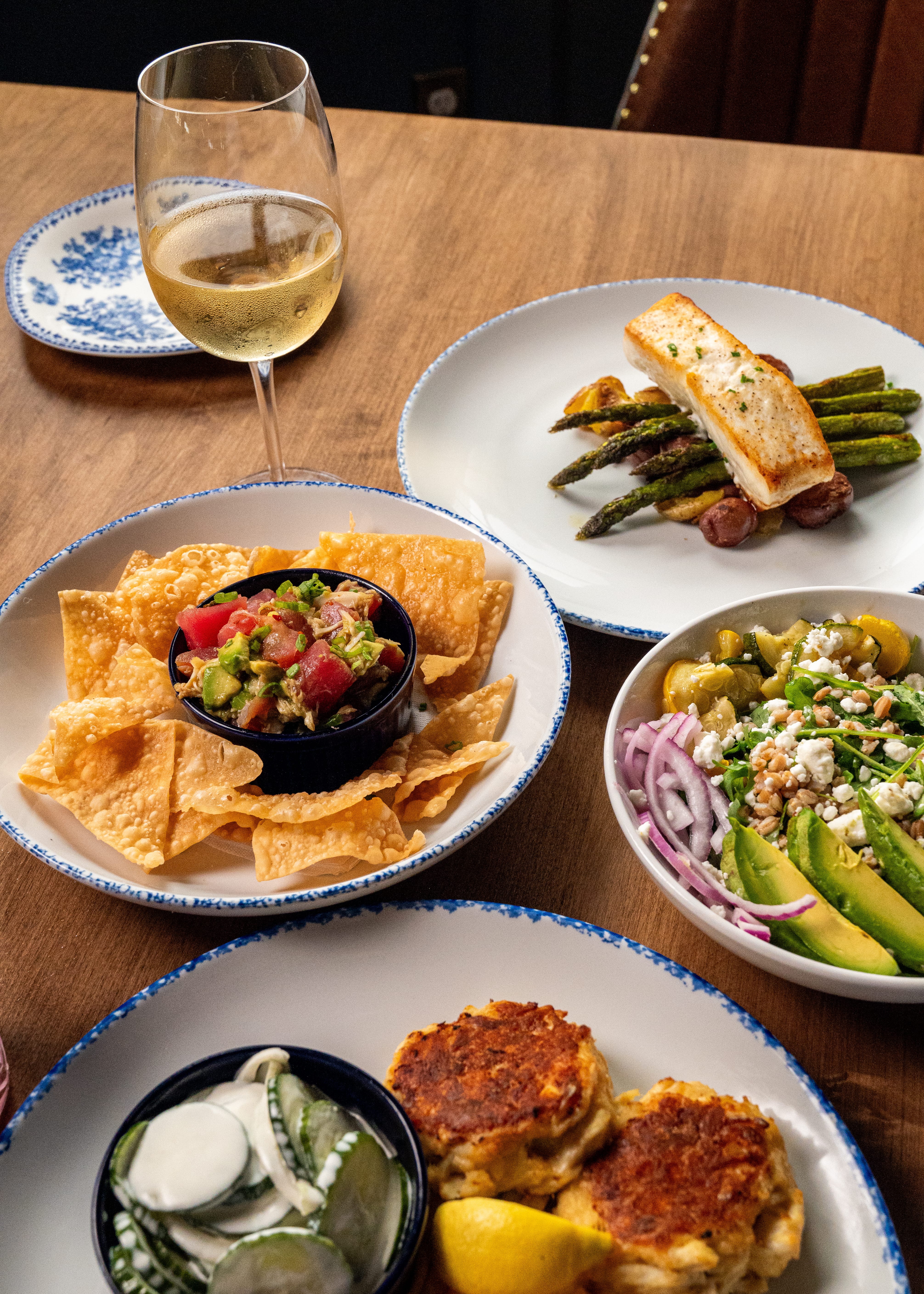 a table with plates of food and a glass of wine