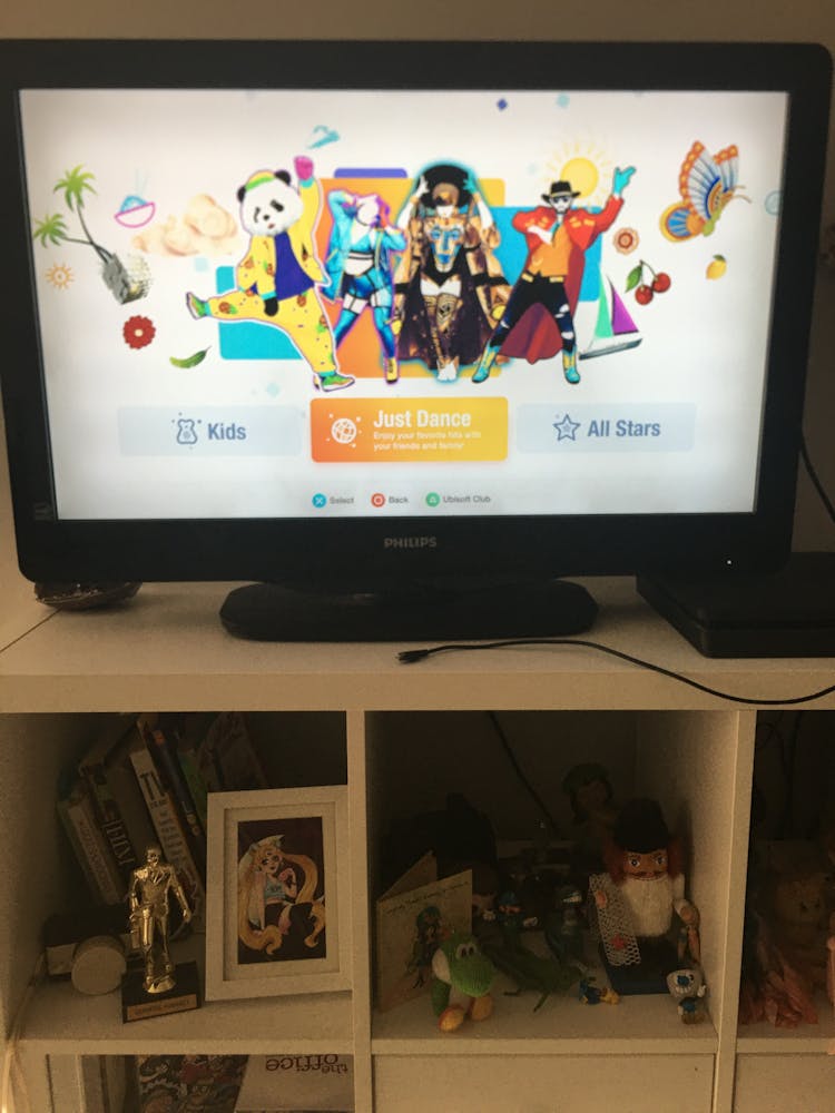 a opening menu screen for Just Dance on TV on stand