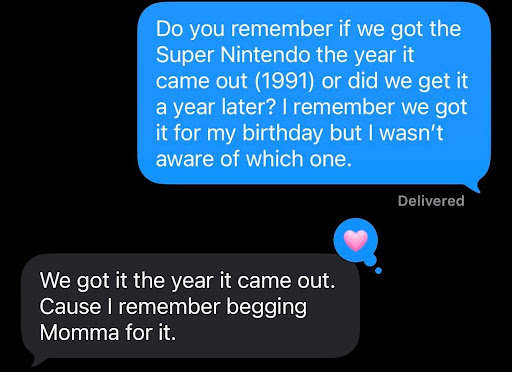 Screenshot of a text exchange. OJ (blue text bubble) says "Do you remember if we got the Super Nintendo the year it came out (1991) or did we get it a year later? I remember we got it for my birthday but I wasn't aware of which one." OJ's brother (grey text bubble) responded: "We got it the year it came out. Cause I remember begging Momma for it."