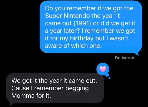 Screenshot of a text exchange. OJ (blue text bubble) says "Do you remember if we got the Super Nintendo the year it came out (1991) or did we get it a year later? I remember we got it for my birthday but I wasn't aware of which one." OJ's brother (grey text bubble) responded: "We got it the year it came out. Cause I remember begging Momma for it."