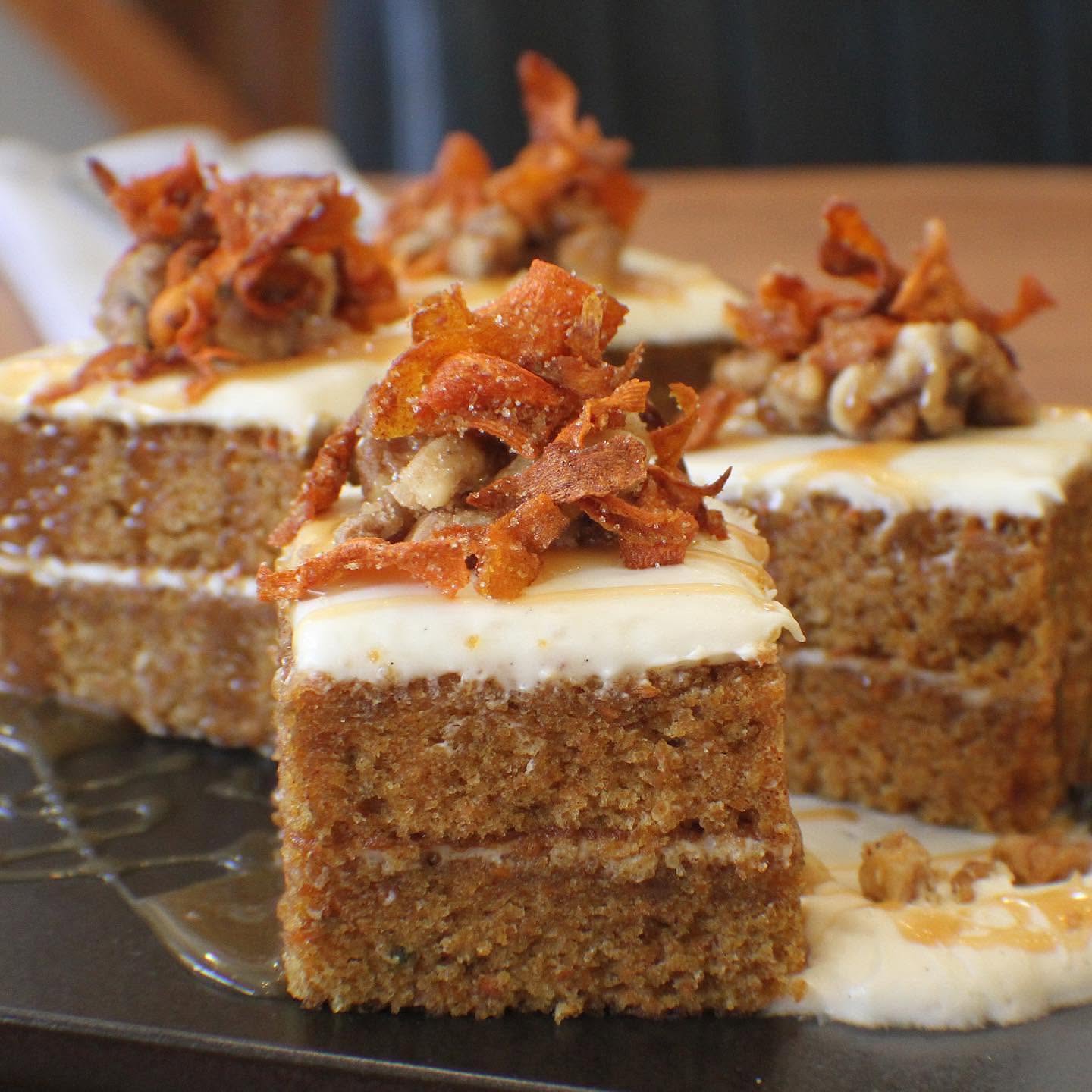Pieces of carrot cake with white frosting and nuts