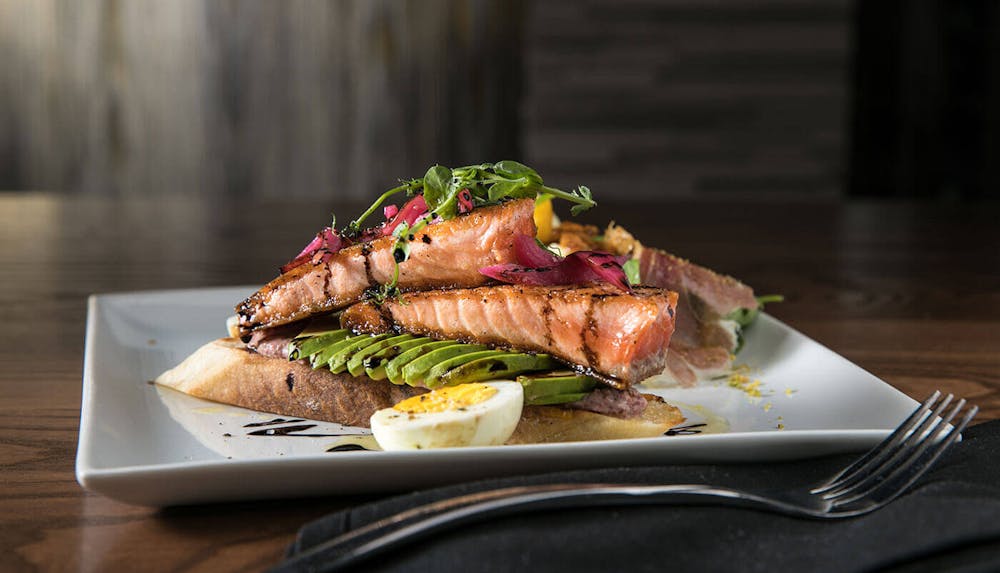 a sandwich sitting on top of a plate of food on a table