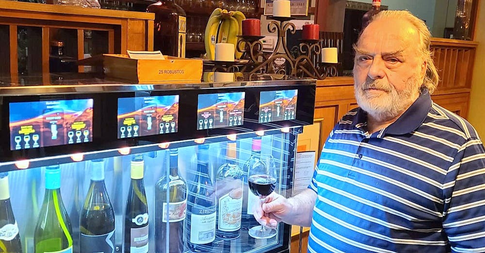 a person standing next to a bottle of wine