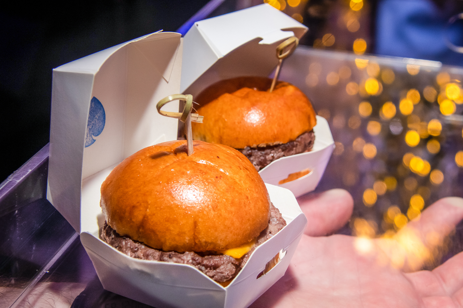 a hand holding a box of donuts