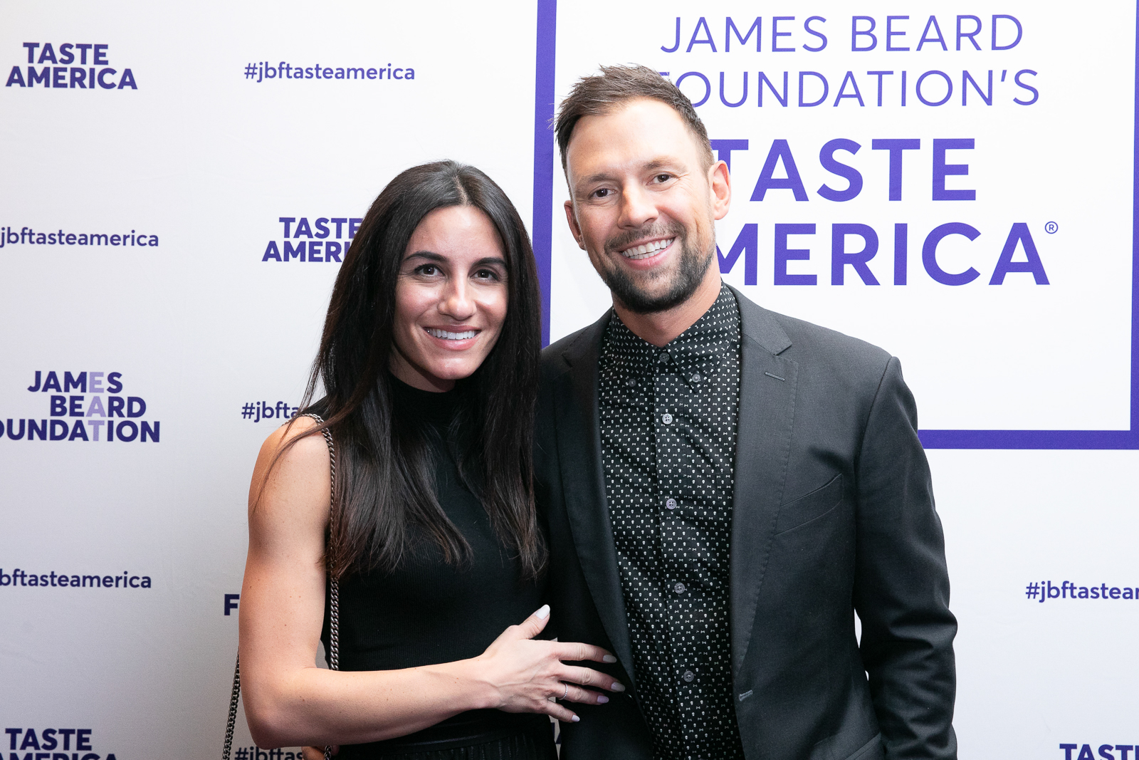 David Rekhson et al. smiling and holding a sign posing for the camera