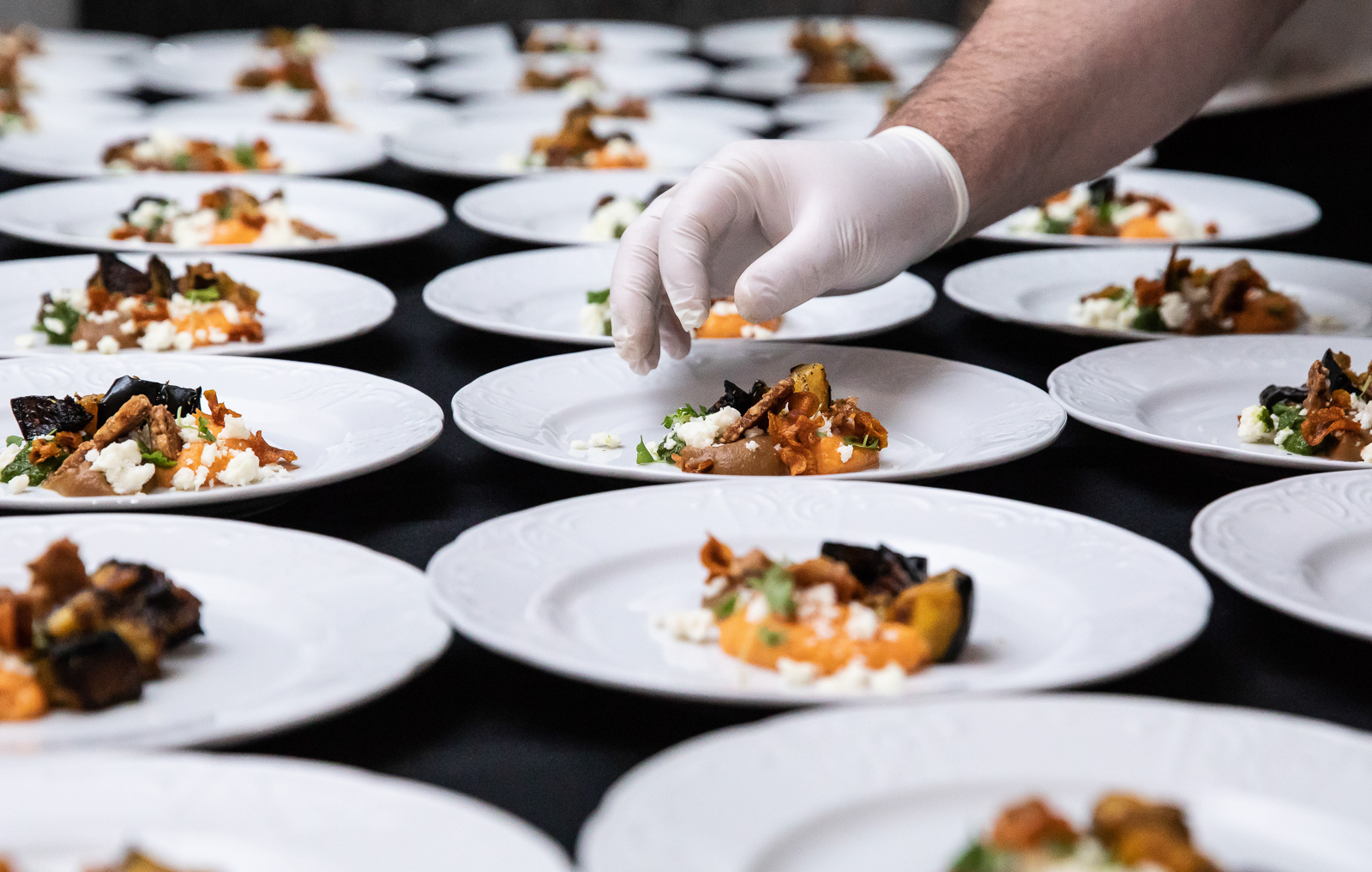 a group of men sitting at a table with a plate of food