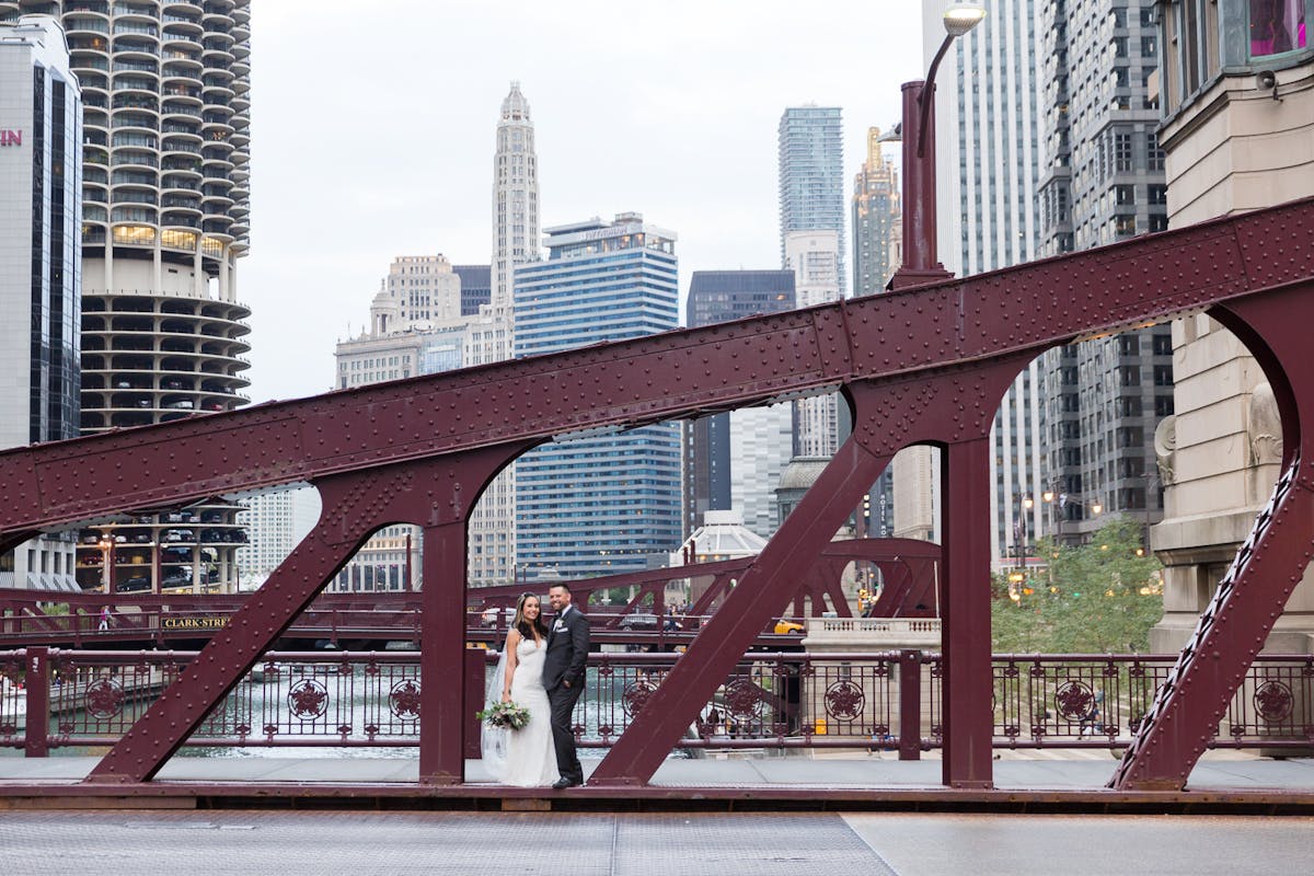 a train crossing a bridge over a river in a city