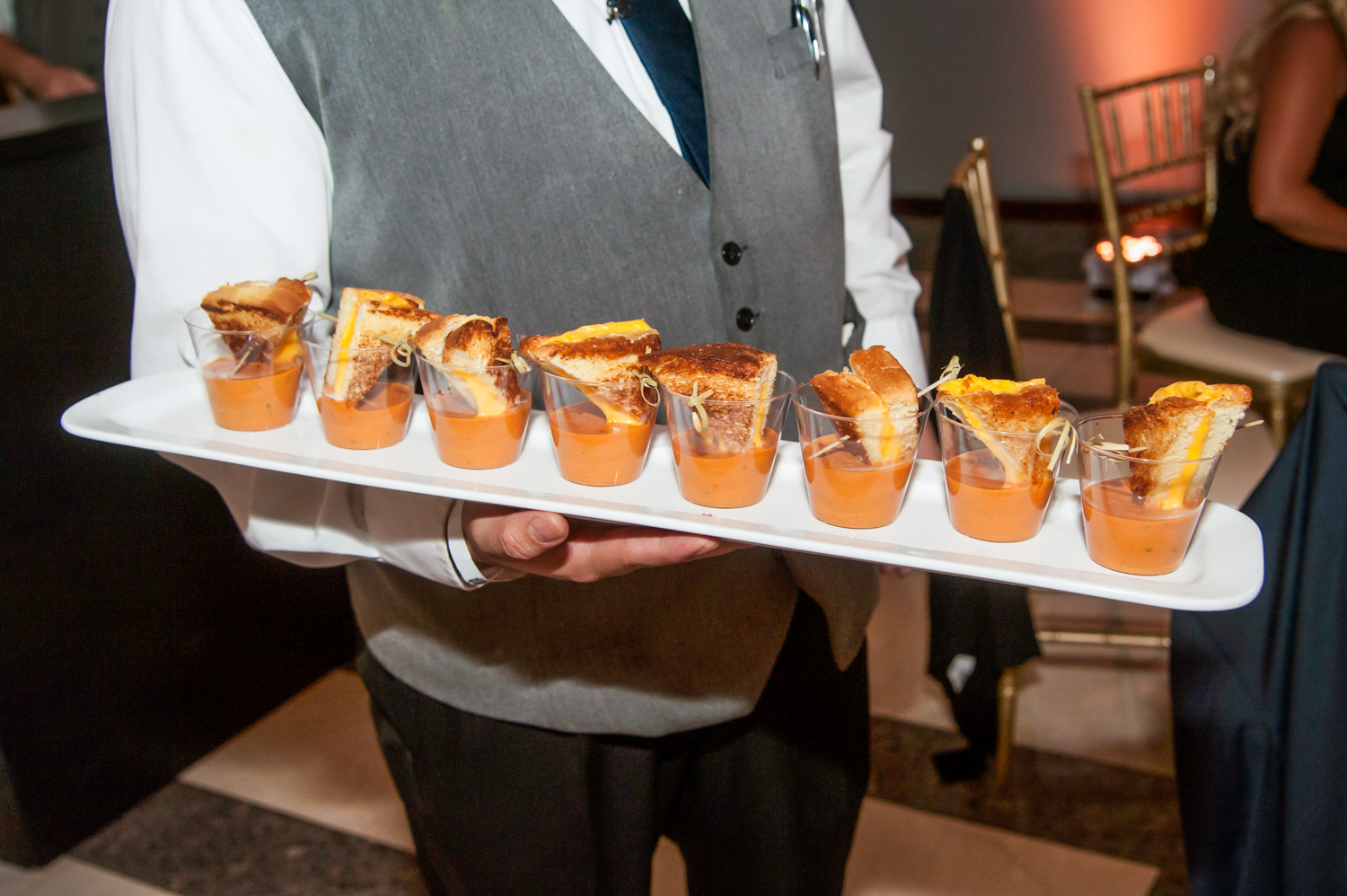 a person sitting at a table with a plate of hot dogs