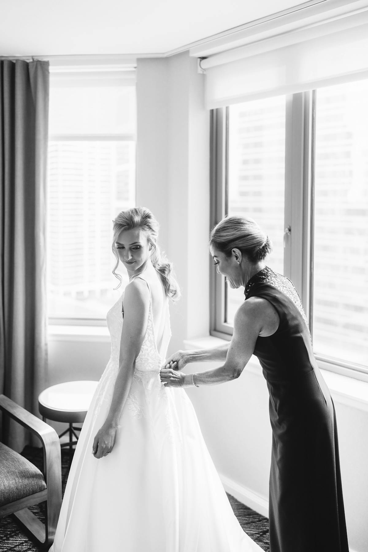 Bride getting wedding dress buttoned up