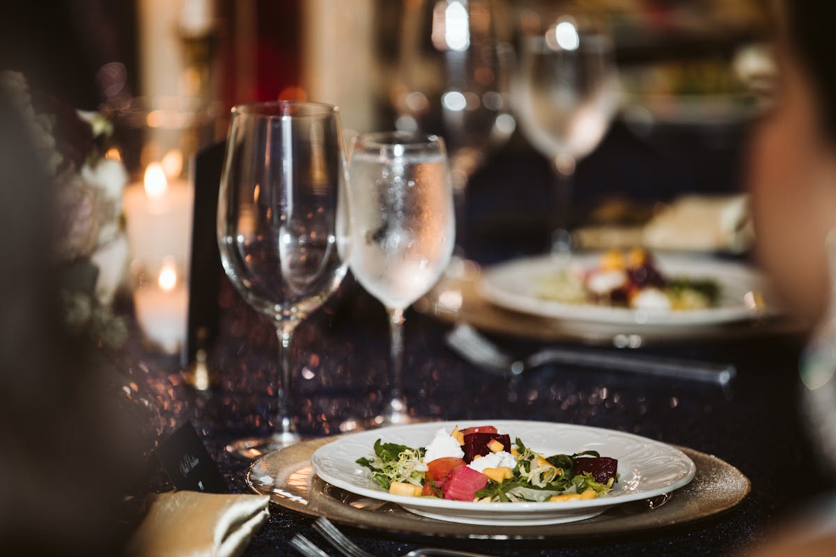 a close up of a plate of food and glasses of wine
