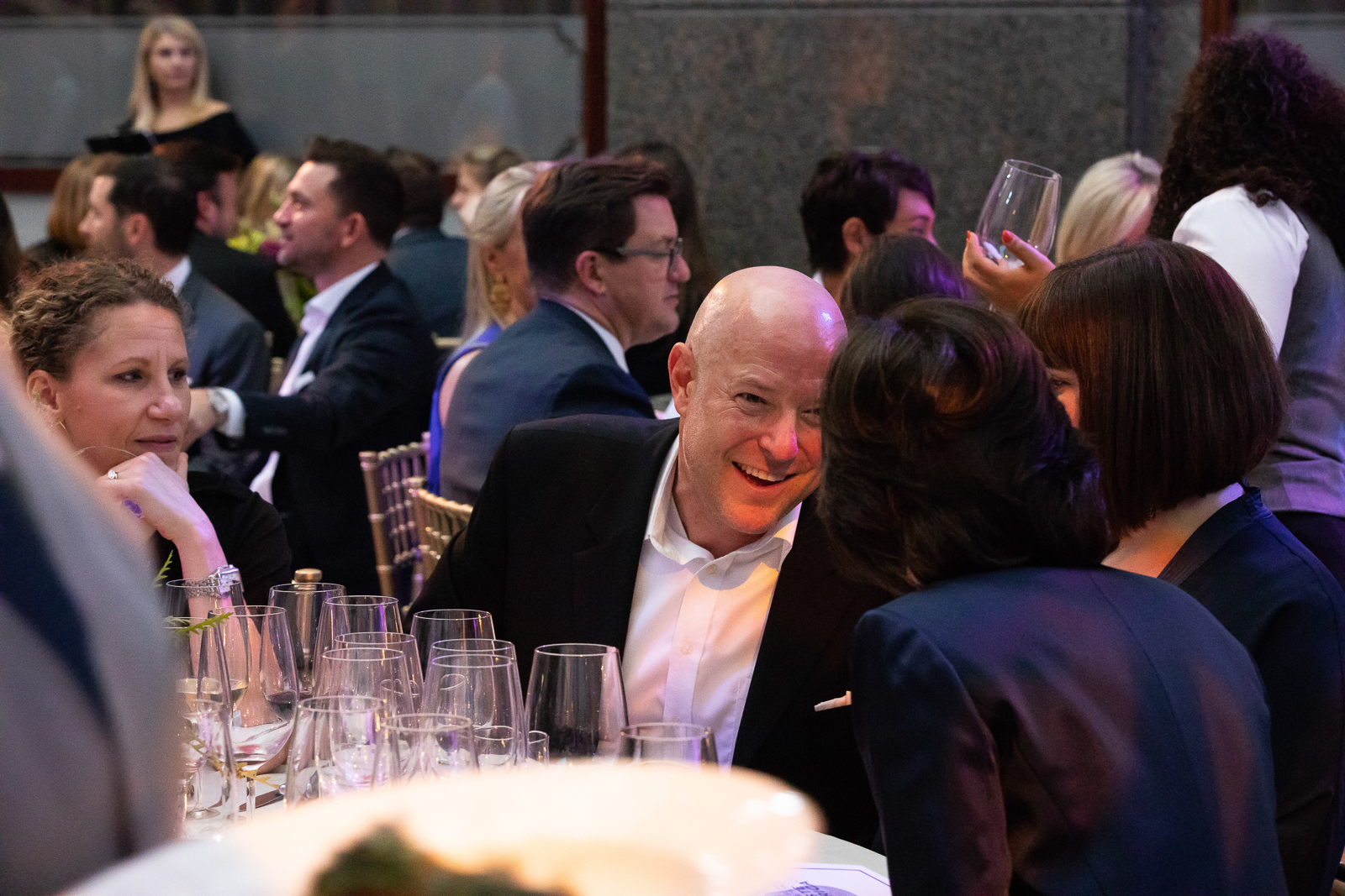 a group of people sitting at a table with wine glasses