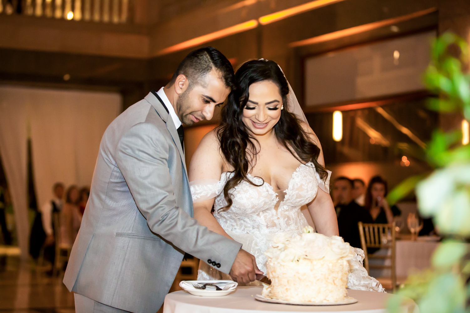 a person cutting a wedding cake