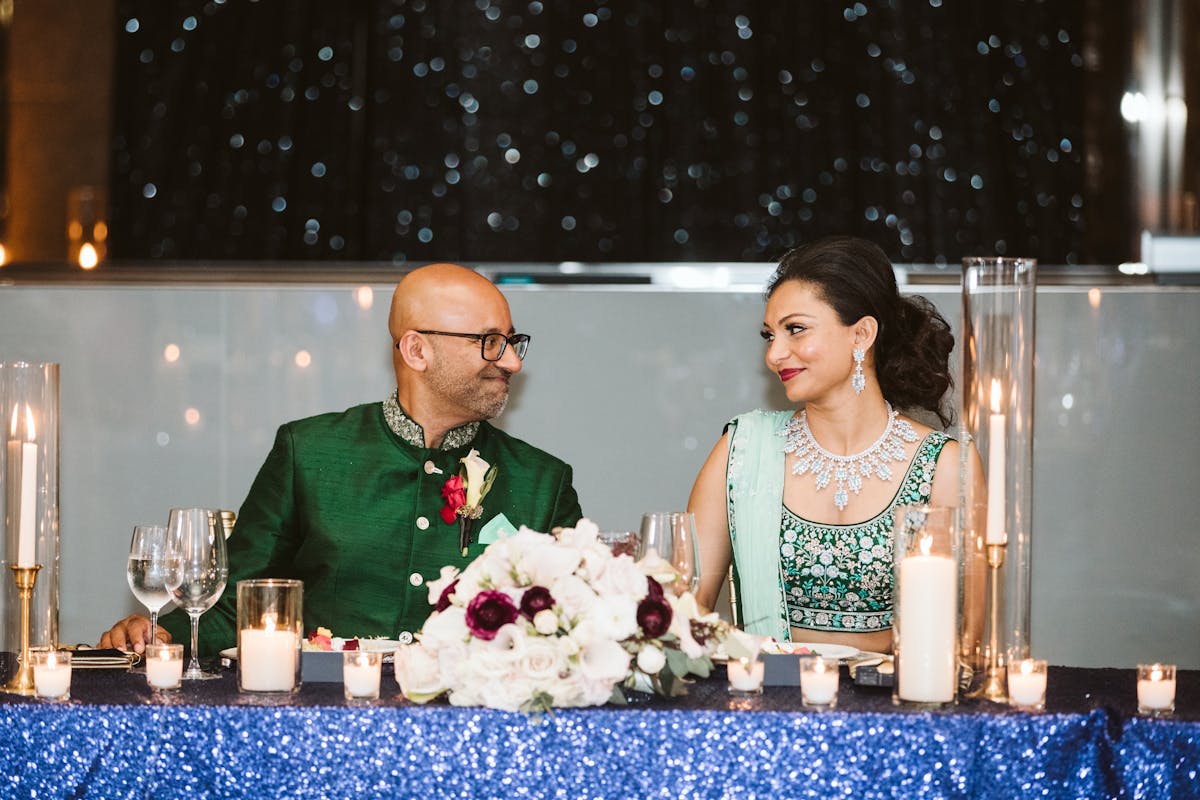 a group of people sitting at a table with a cake