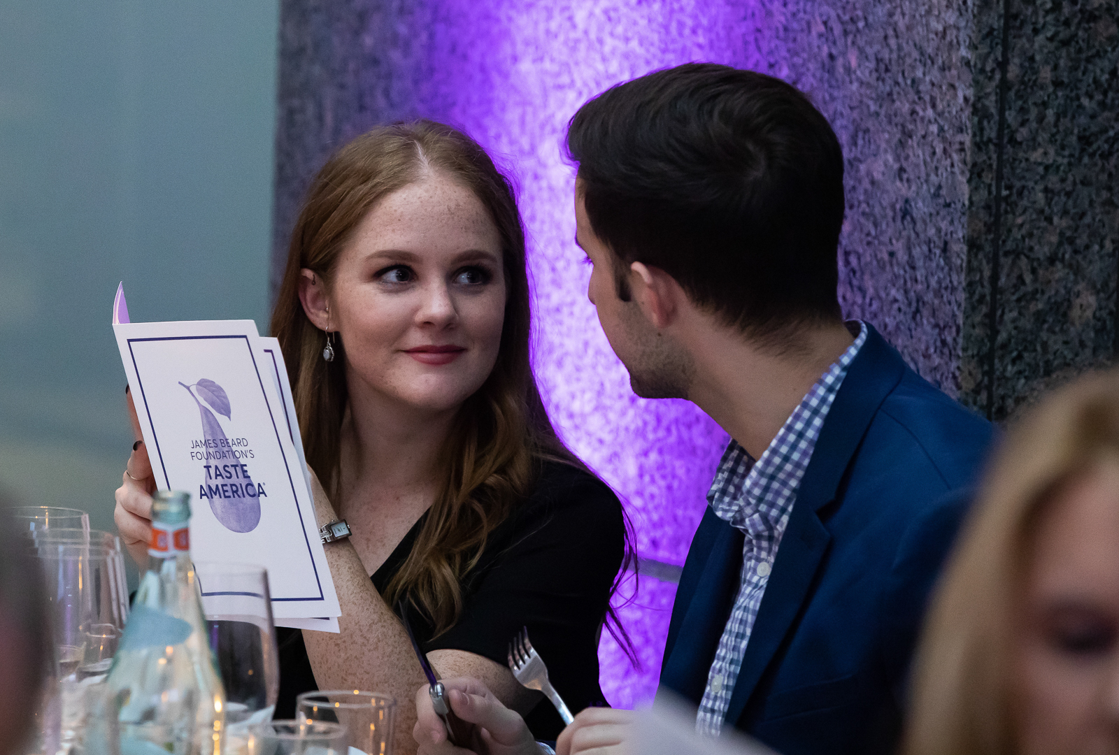 a person sitting at a table with wine glasses